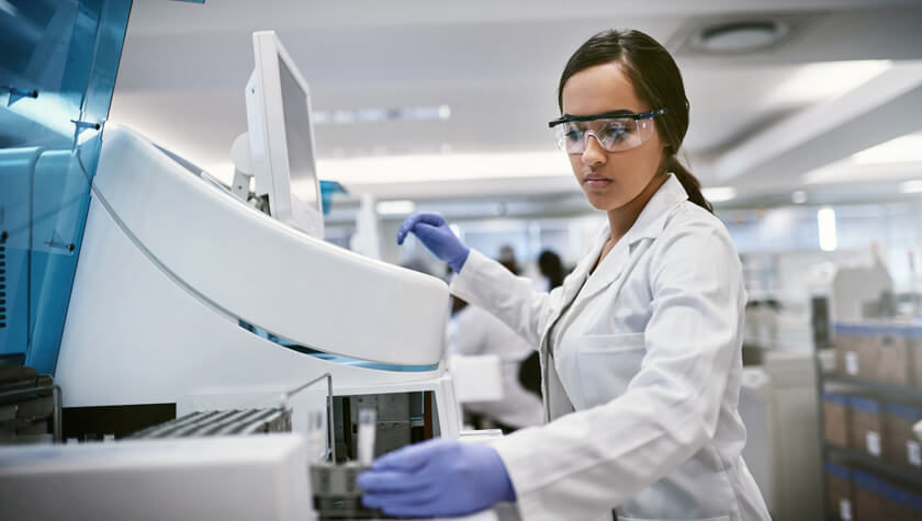 A student removes a sample in a lab experiment