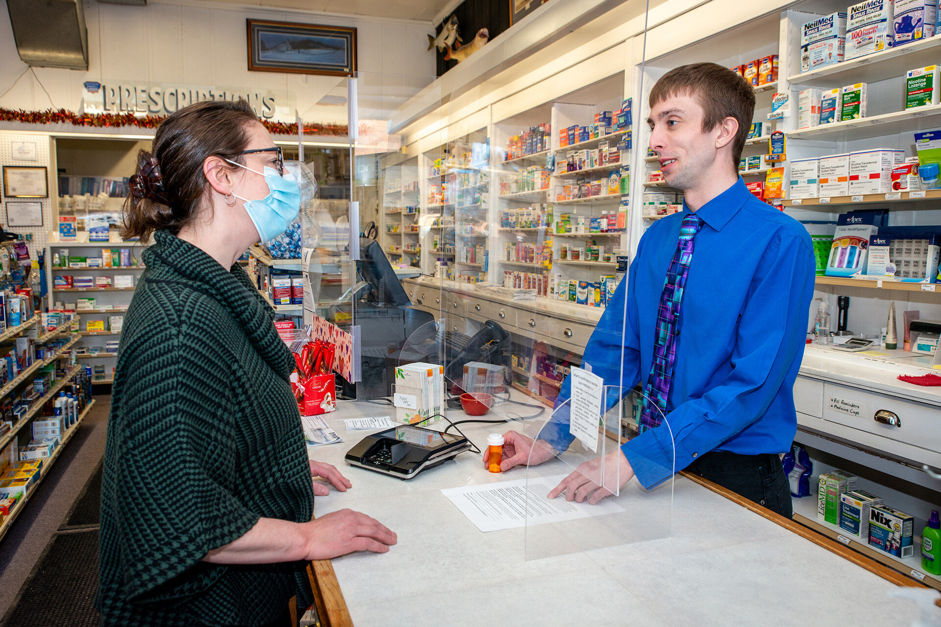 Community pharmacist Aaron Gehrke helps a patient with her medication question