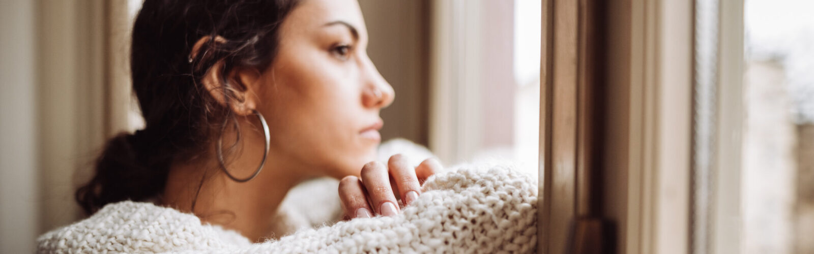 pensive woman in front of the window