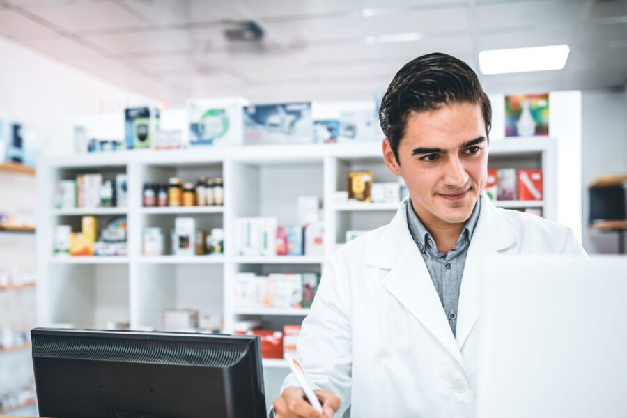 young male pharmacist working at counter