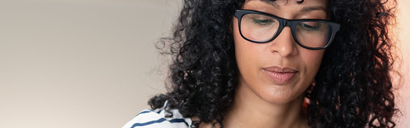 woman with brown curly hair and glasses