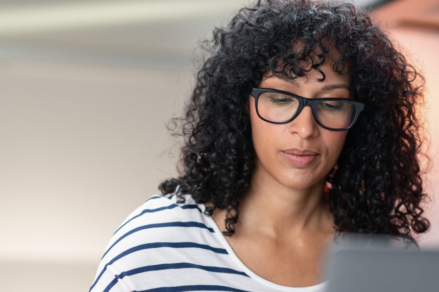 woman with brown curly hair and glasses