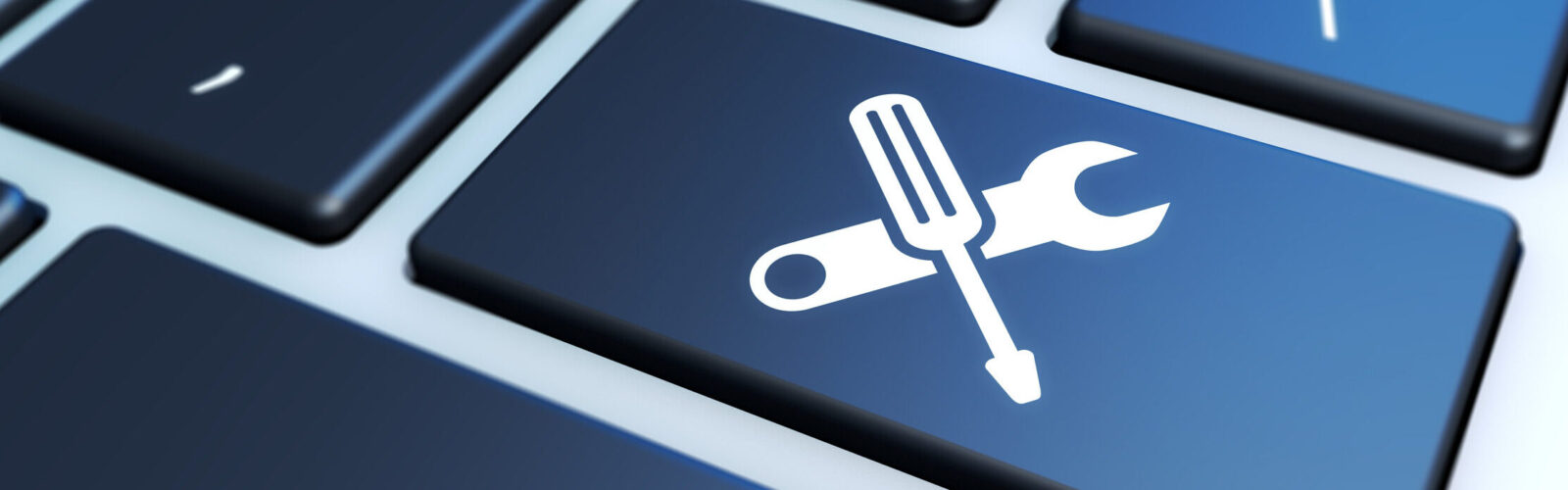 key on laptop with tools forming an X