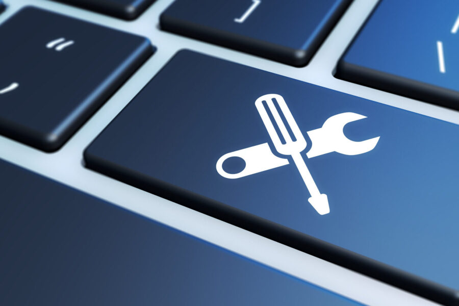 key on laptop with tools forming an X