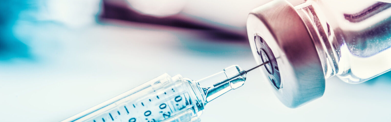 vial with hypodermic needle withdrawing fluid