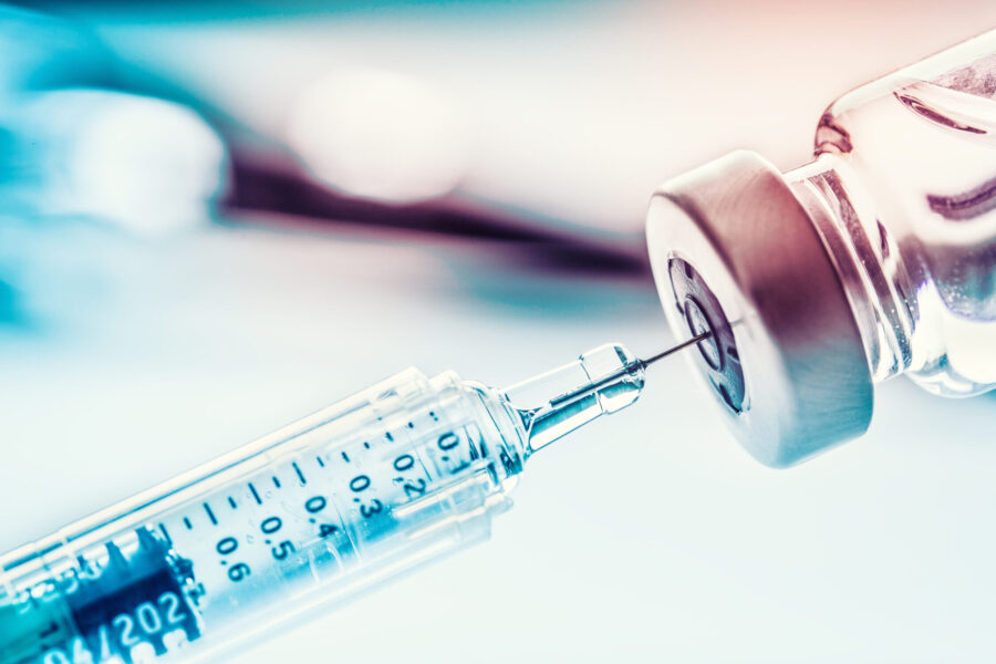 vial with hypodermic needle withdrawing fluid