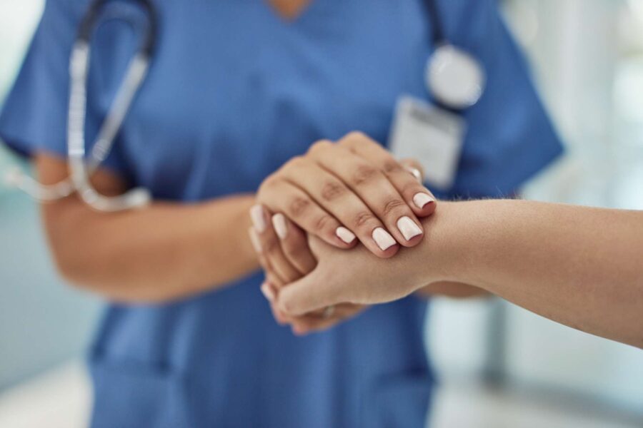 female doctor holding someone's hand