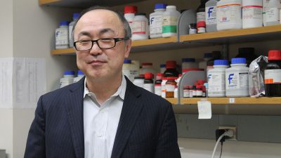 Glen Kwon standing next to a shelf of pharmaceuticals