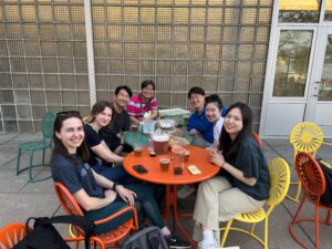 Hong Research members sitting around two tables on the terrace with beer pitchers and cups in front of them