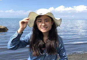 Ao Wang in a hat by the water