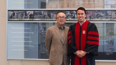 Dr. Glen Kwon with a graduated Tony Tam in his graduation gown