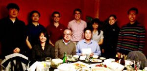 Kwon Research group all gathered behind a table for a group picture at a restaurant