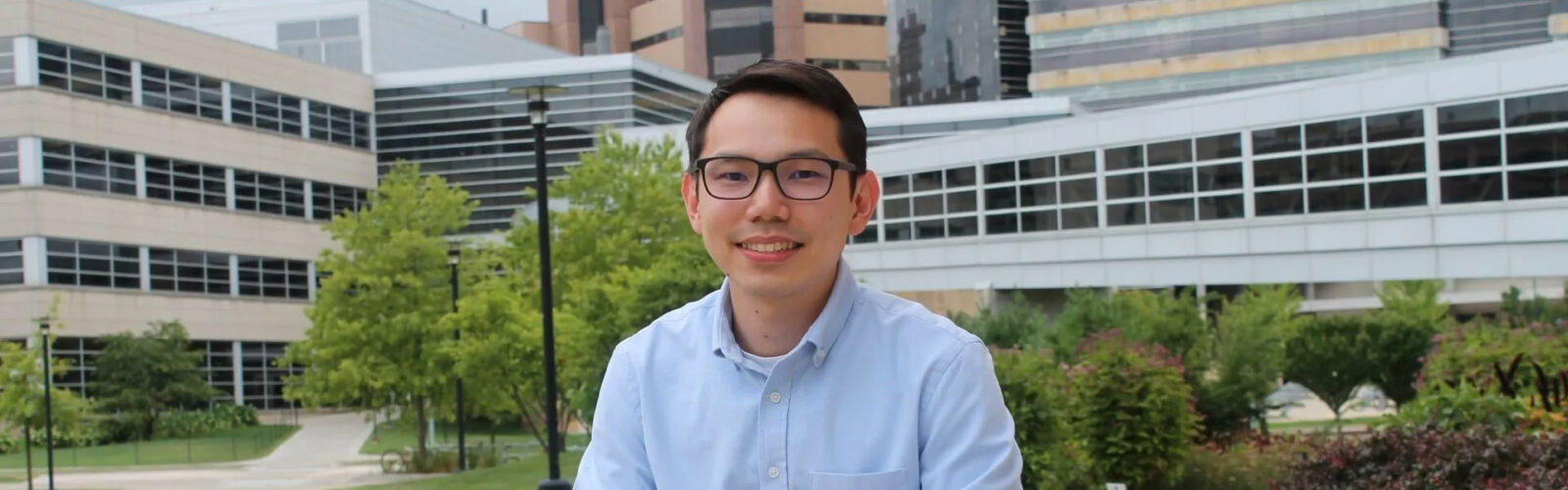 Image of Sin Yin (Sean) Lim with the buildings in the background