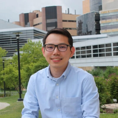 Image of Sin Yin (Sean) Lim with the buildings in the background