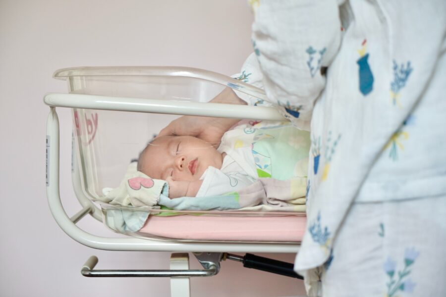 Picture of a baby in a clear hospital bassinet