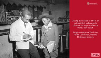 1944 black male pharmacist buying war bonds from a black boy scout.