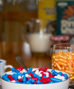 a cereal bowl of pills and glass of pills