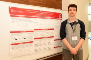 Adam Worob standing with his research for the MIKIW conference