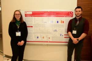 Nate Jones and Laura Wagner standing with their research for the MIKIW conference
