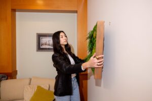 someone hanging a decorative display on the wall