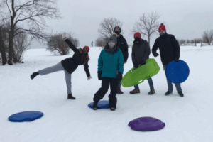 Wenthur lab members in a wintry landscape with coats and sleds
