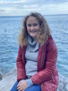 Kennedy Borchardt sitting outside in front of water