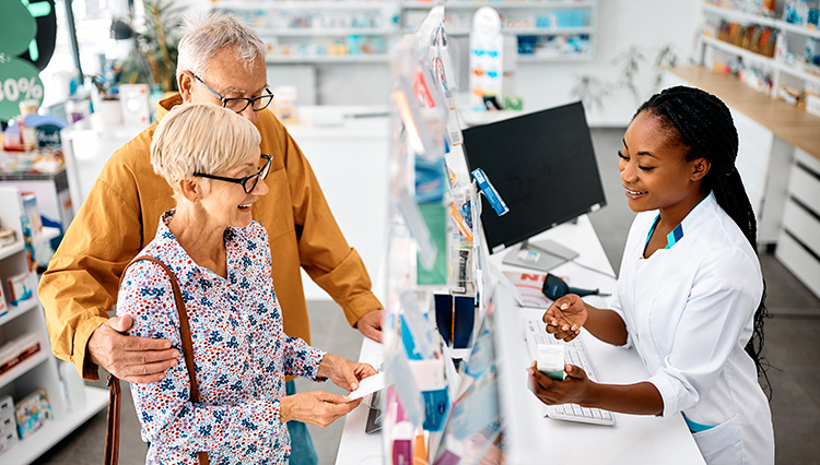 a female pharmacist answers questions about a medication for an elderly couple