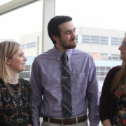 Three pharmacy students converse together in the hall