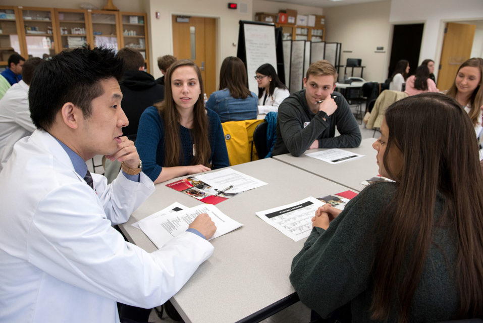 A 2nd year pharmacy student speaks with prospective students at an open house event