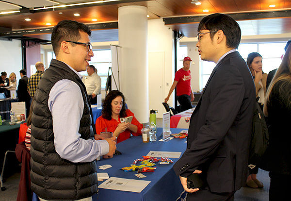 An employer answers questions for two pharmacy students at the career fair