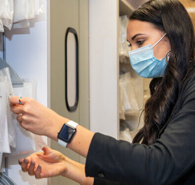 Pharmacy alumna Kymberly Ludwig examines medication paperwork on a shelf