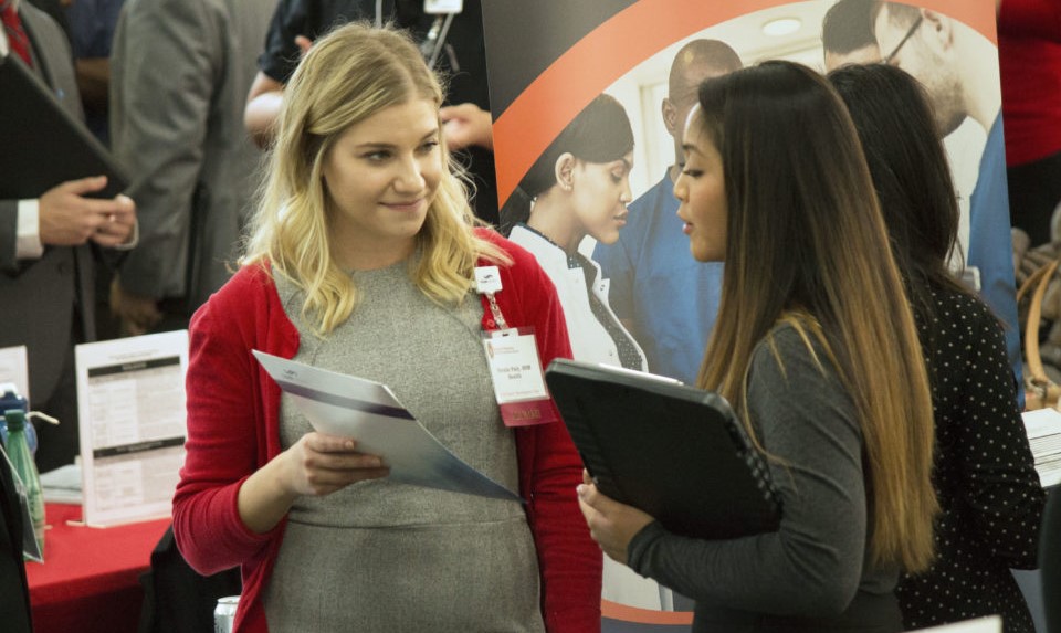 A pharmacy student chats with a representative at the annual Career Fair.