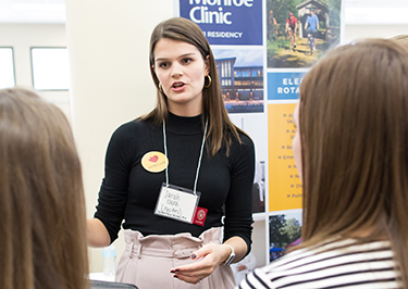 Monroe Clinic pharmacist Sarah Clark talks to two PharmD students at the annual Career Fair.