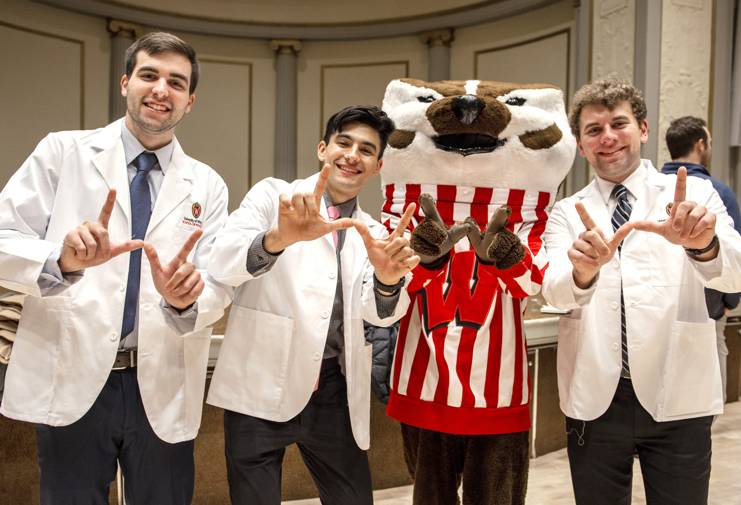 Students pose for a photo with Bucky Badger following the white coat ceremony