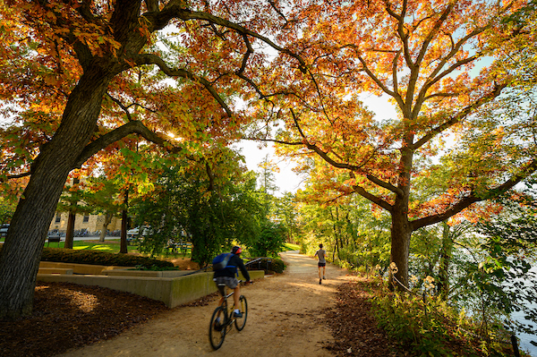 Pedestrians and students walk among the colors of the fall leaves on the Howard Temin Lakeshore Path at the University of Wisconsin-Madison during autumn on October 19, 2021. (Photo by Bryce Richter / UW-Madison)