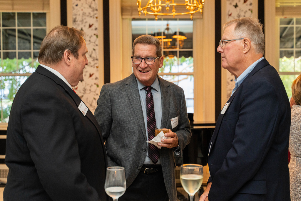 Steve Swanson and Steve Skolaski speak with another male attendee.