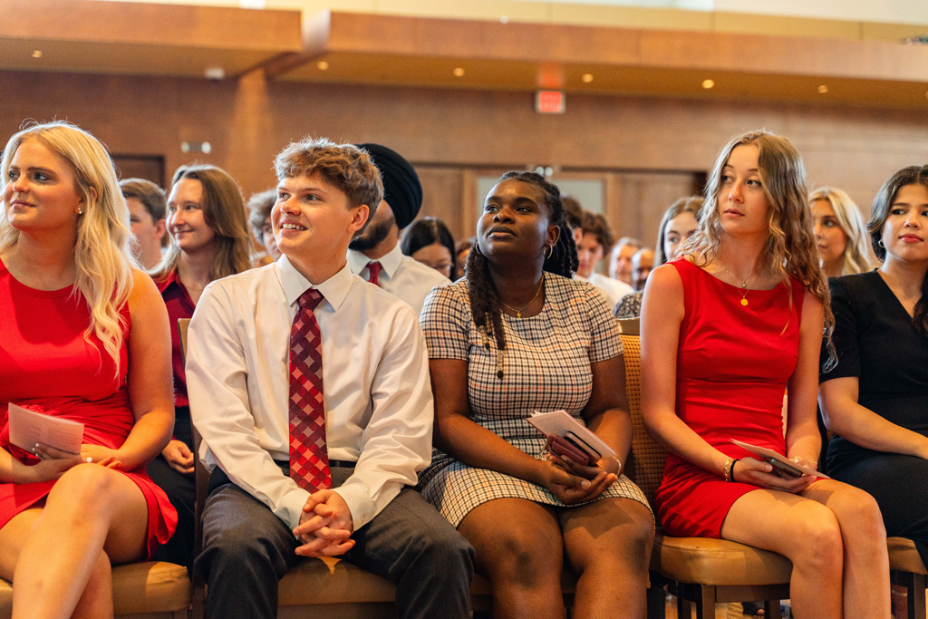 Students sit in their seats awaiting their white coats