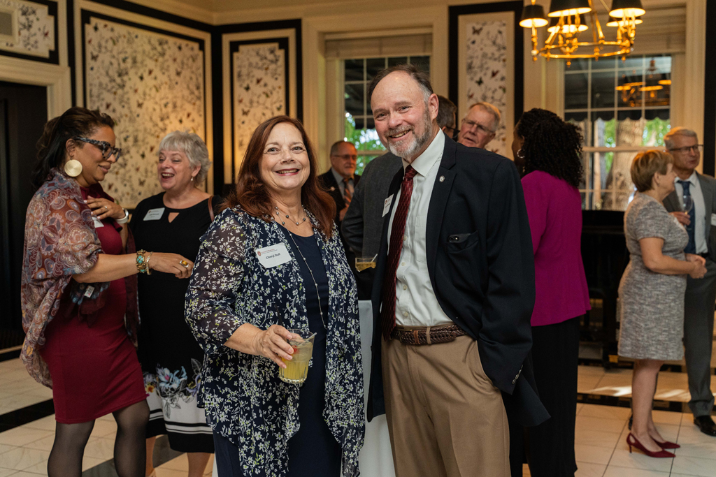 Cheryl Dull and a male attendee pose for a photo.