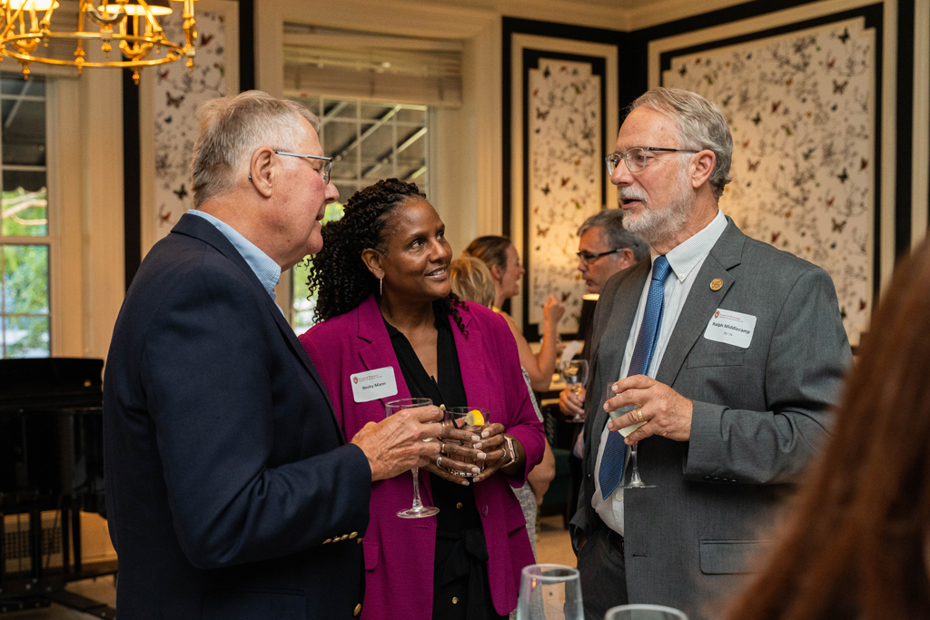 Ralph Middlecamp, Becky Mann, and another attendee engage in conversation.