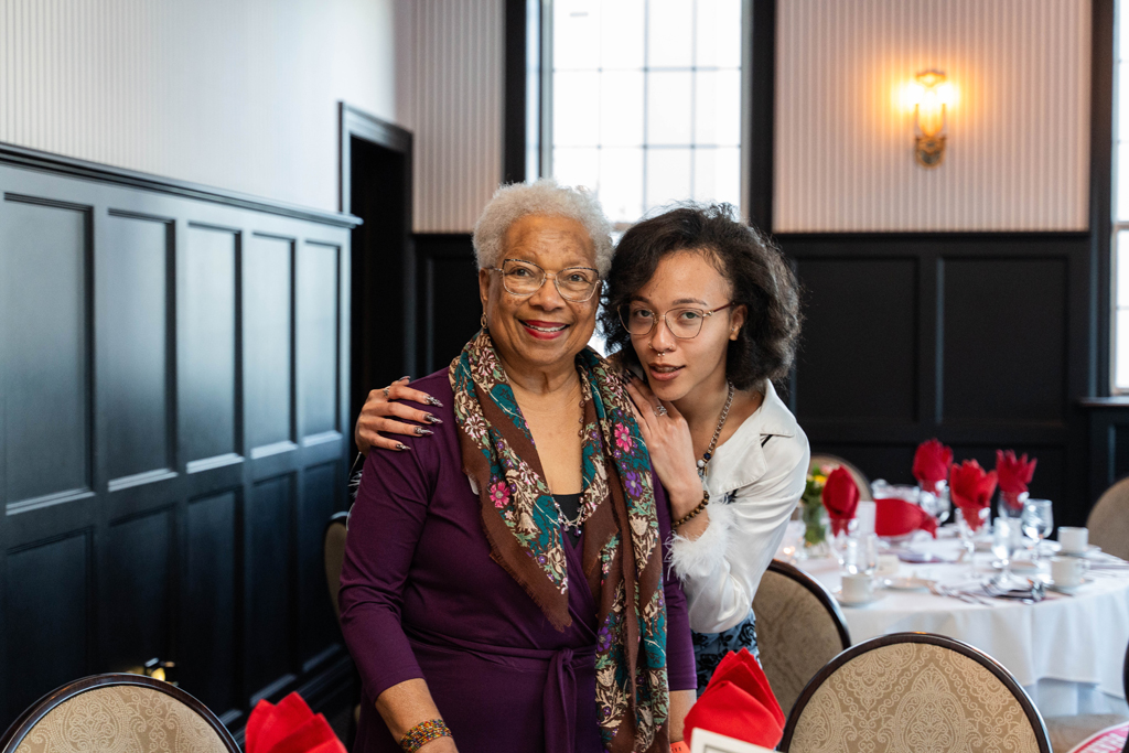 Two female attendees pose for a photo.