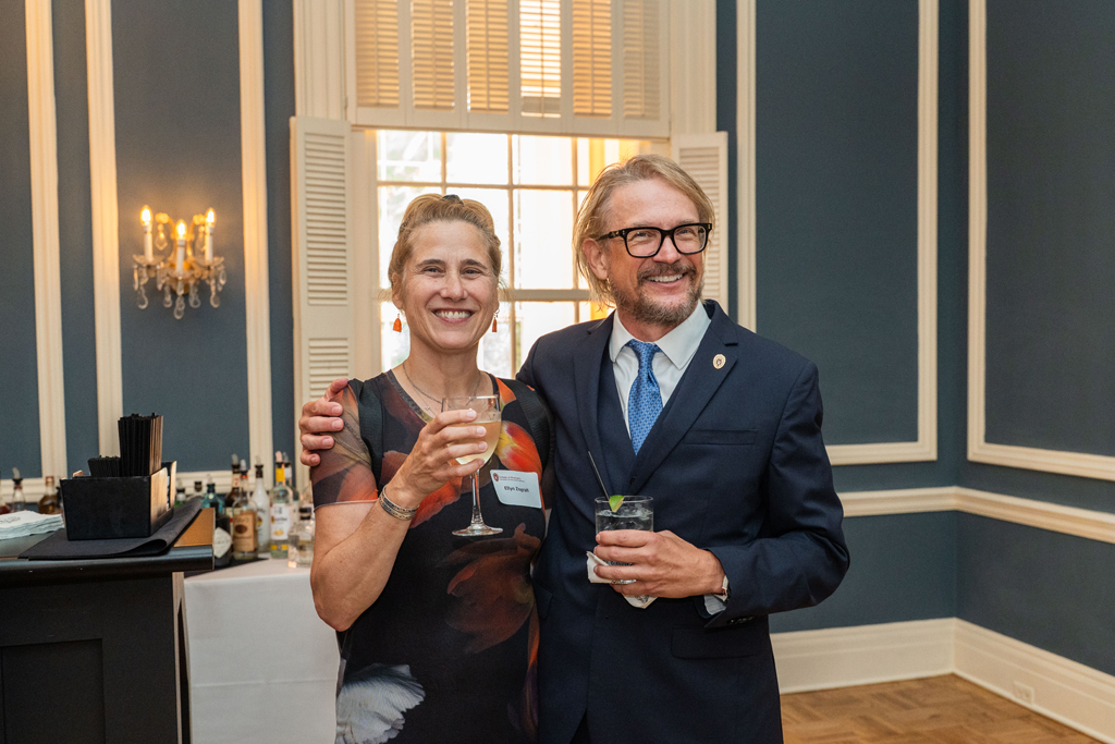 John Hill and another attendee embrace and smile for a photo