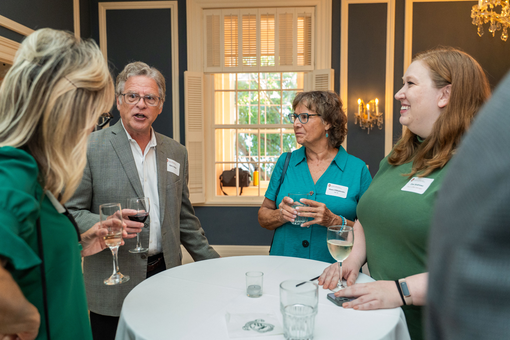 Beth Martin, Barry Gidal, Zoe Andrews, and another attendee speak around a table