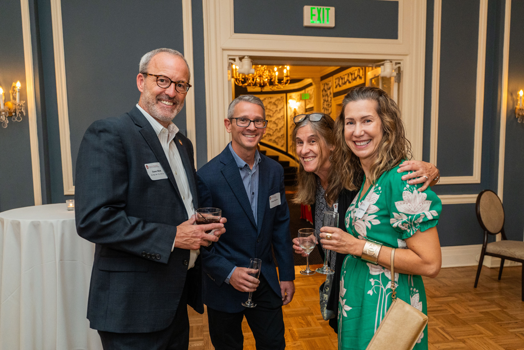 Dave Mott poses with three other attendees, all holding beverage glasses