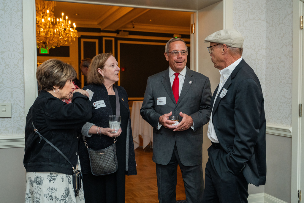 Daniel Langer speaks with Jeff and Patti Langer and another attendee