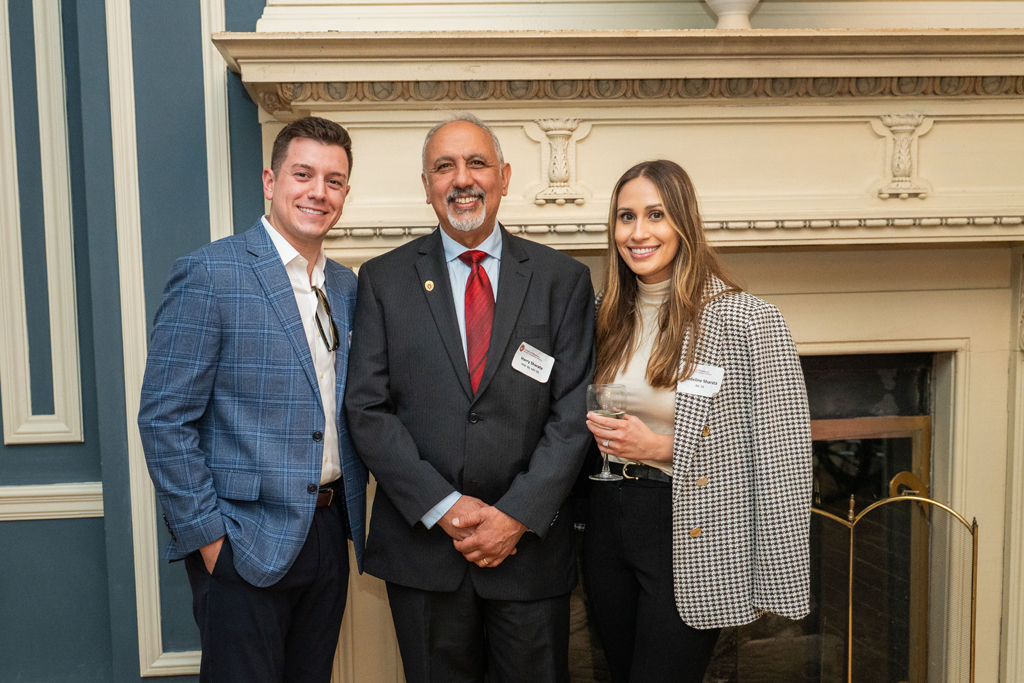 Harry Sharata smiles and poses with two younger attendees