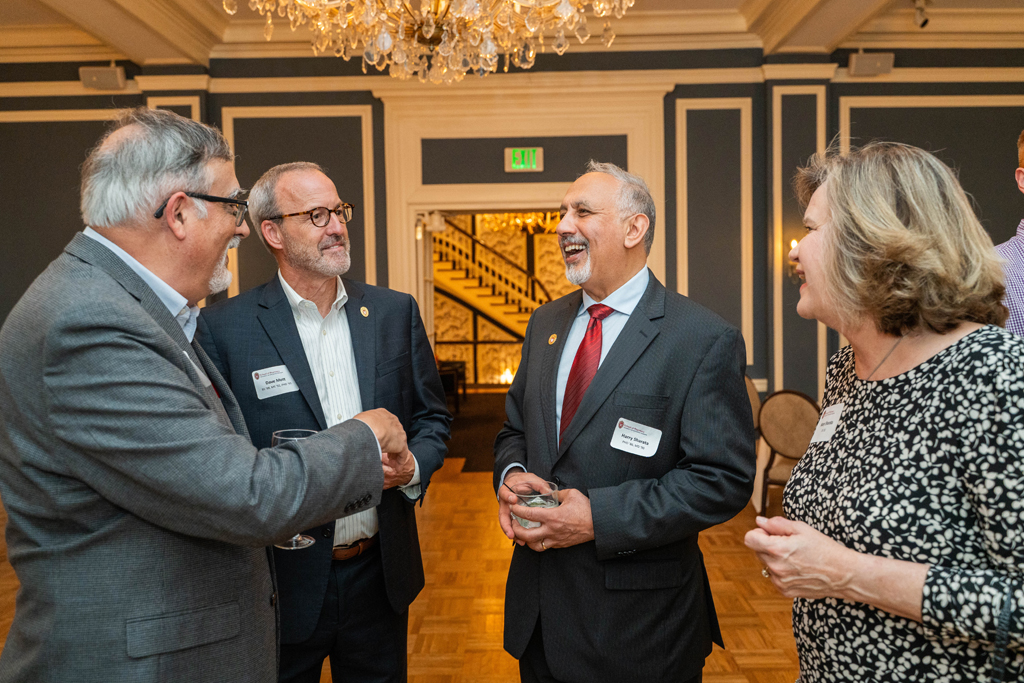 Harry Sharata speaks with Greg Higby, Dave Mott, and another attendee