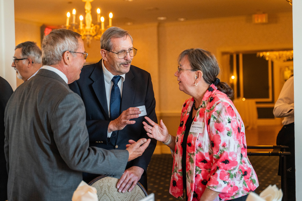 Gary Girdakis speaks with Martha Girdakis and another attendee