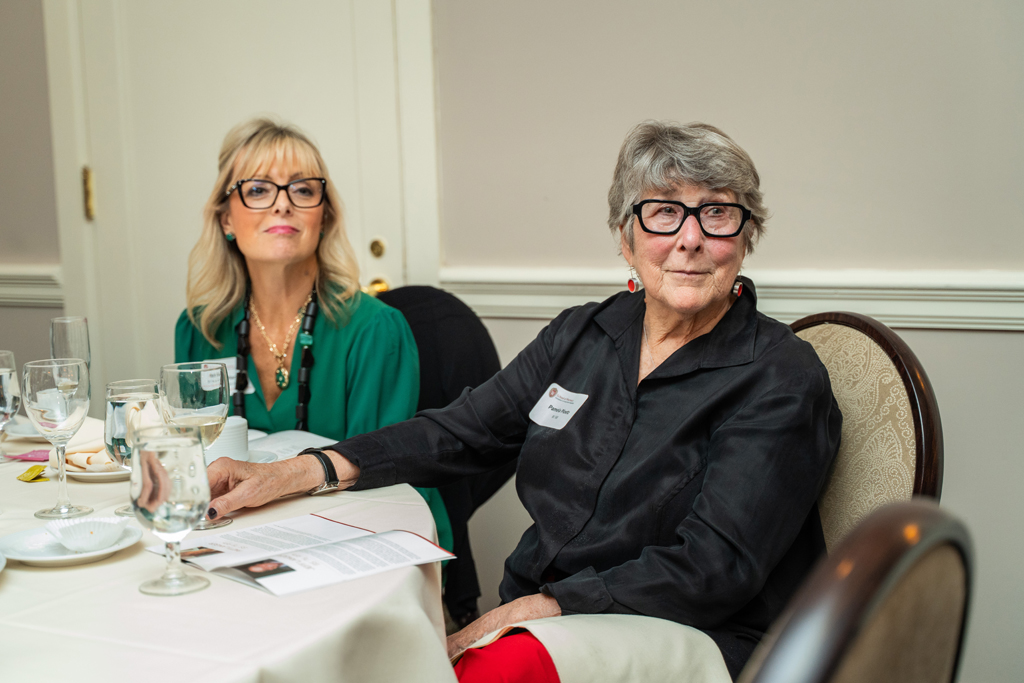 Two women, Beth Martin and Pam Ploetz, are seated at a dinner table.