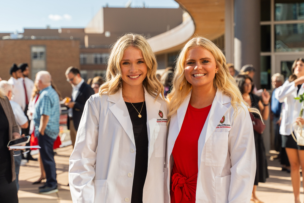 Two female students pose for a photo outside