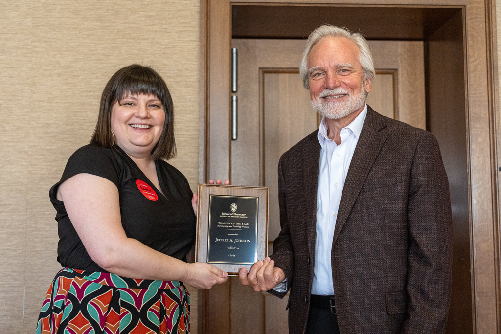 Kendra Gurnee hands Jeff Johnson an award plaque
